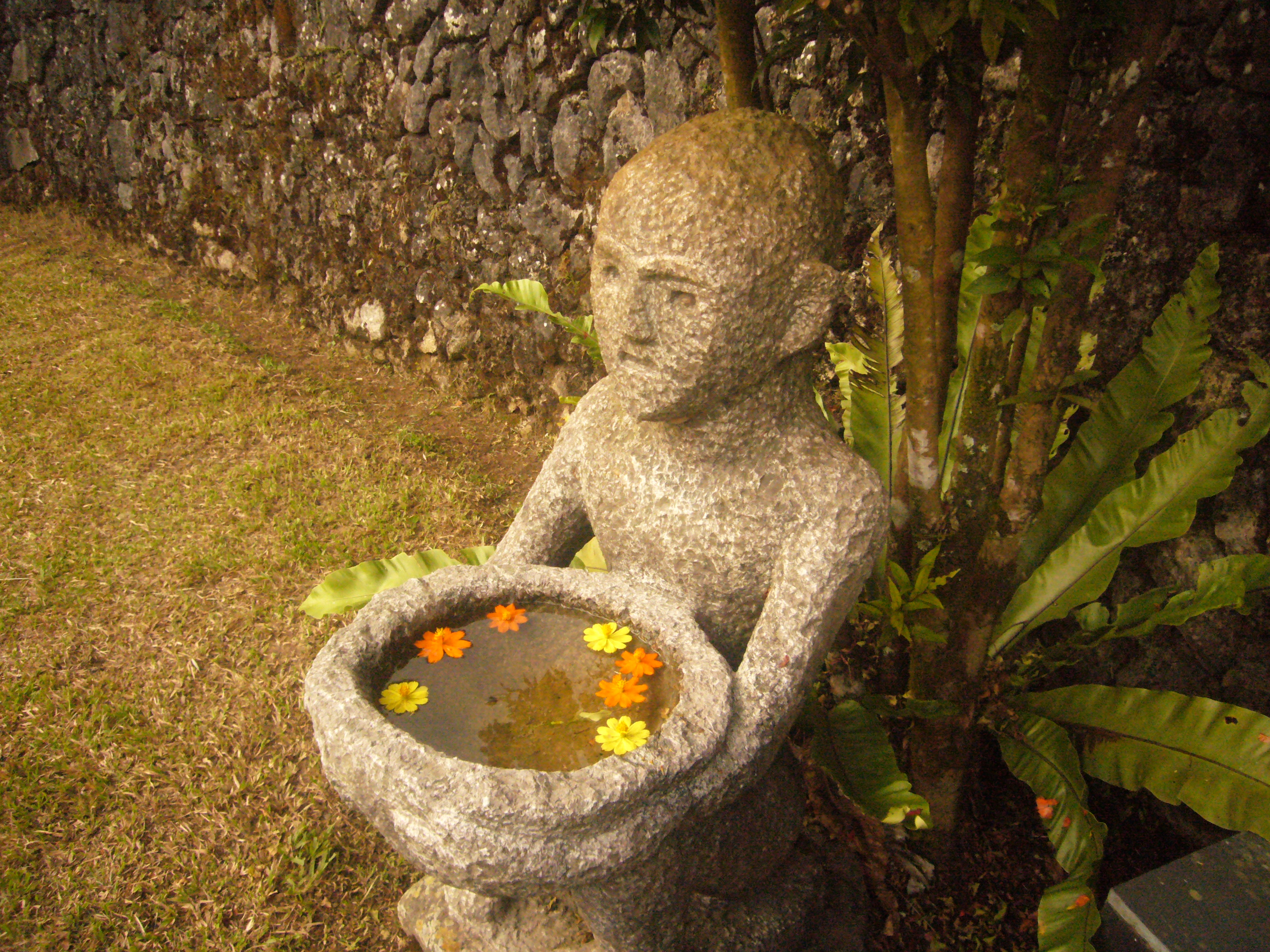 Small stone statue with floating flowers